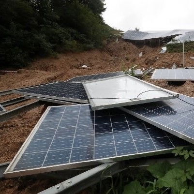 A stack of solar panels scattered on the ground.